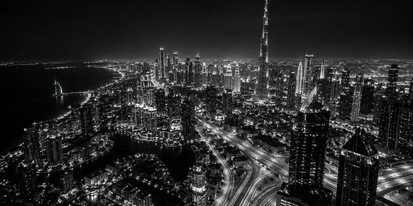 Black-and-white aerial view of Dubai and the Burj Khalifa at night