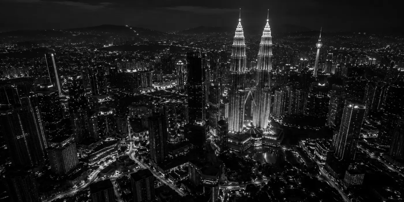 Black-and-white aerial view of Kuala Lumpur and the Petronas Twin Towers at night